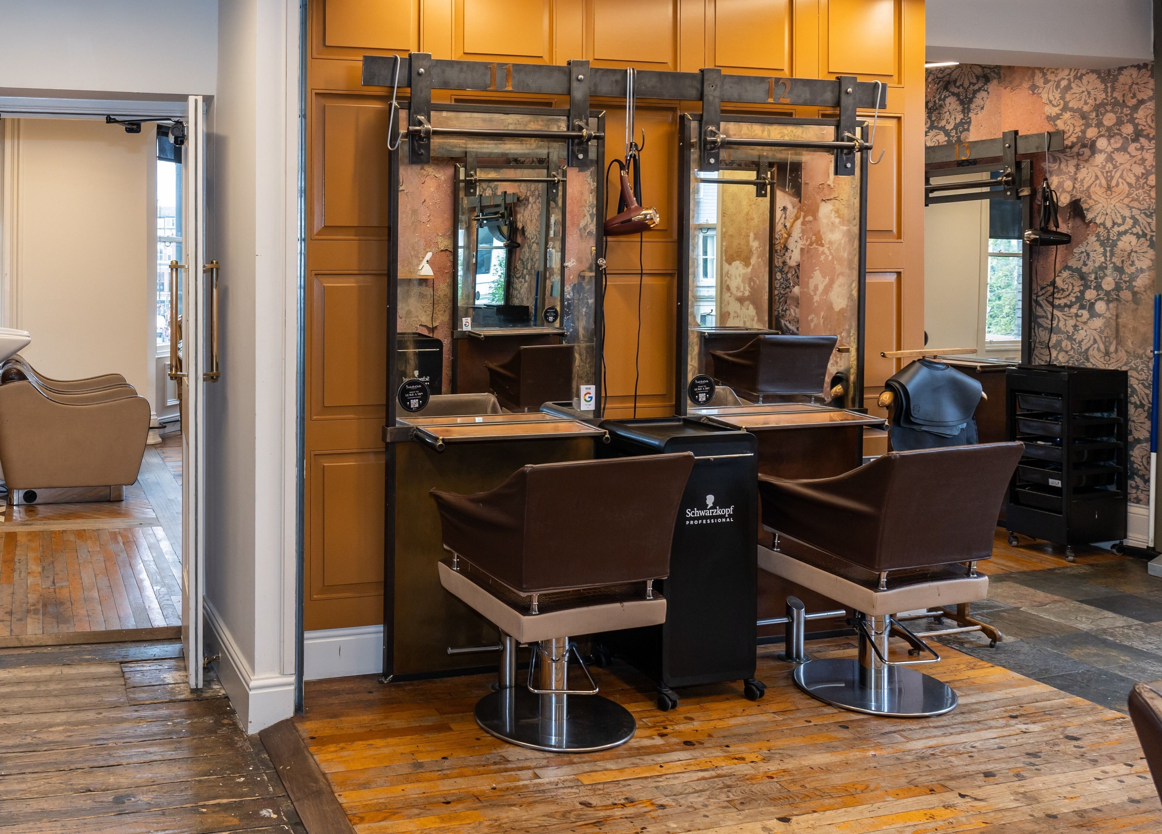 Elegant salon styling area at Boilerhouse - Jesmond, Newcastle upon Tyne, England, GB with chic mirrors and chairs.