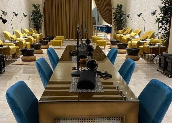 Elegant interior of The Bliss Nails in Riyadh, SA with plush seating and nail stations.