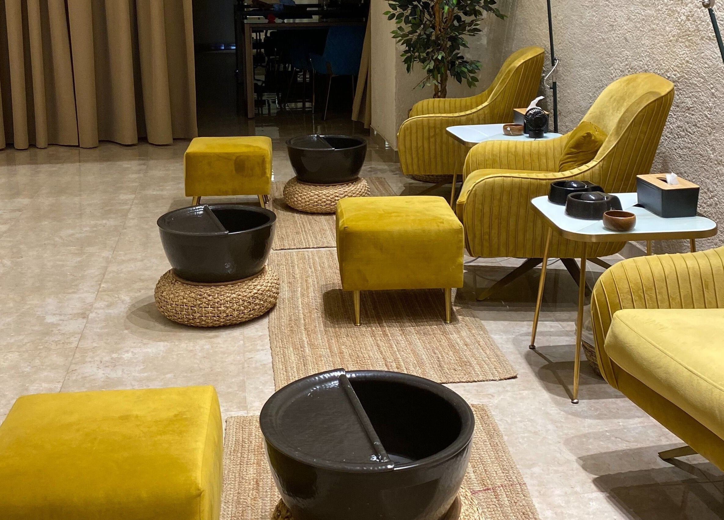 Cozy pedicure setup at The Bliss Nails, Riyadh, SA with plush yellow seating and elegant decor.