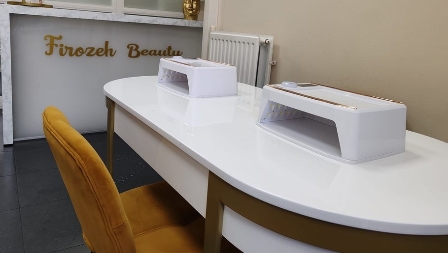 Elegante nageltafel bij Firozeh Beauty, Leiden, Zuid-Holland, NL, met luxe gouden stoel en moderne apparatuur.
