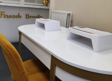 Elegante nageltafel bij Firozeh Beauty, Leiden, Zuid-Holland, NL, met luxe gouden stoel en moderne apparatuur.