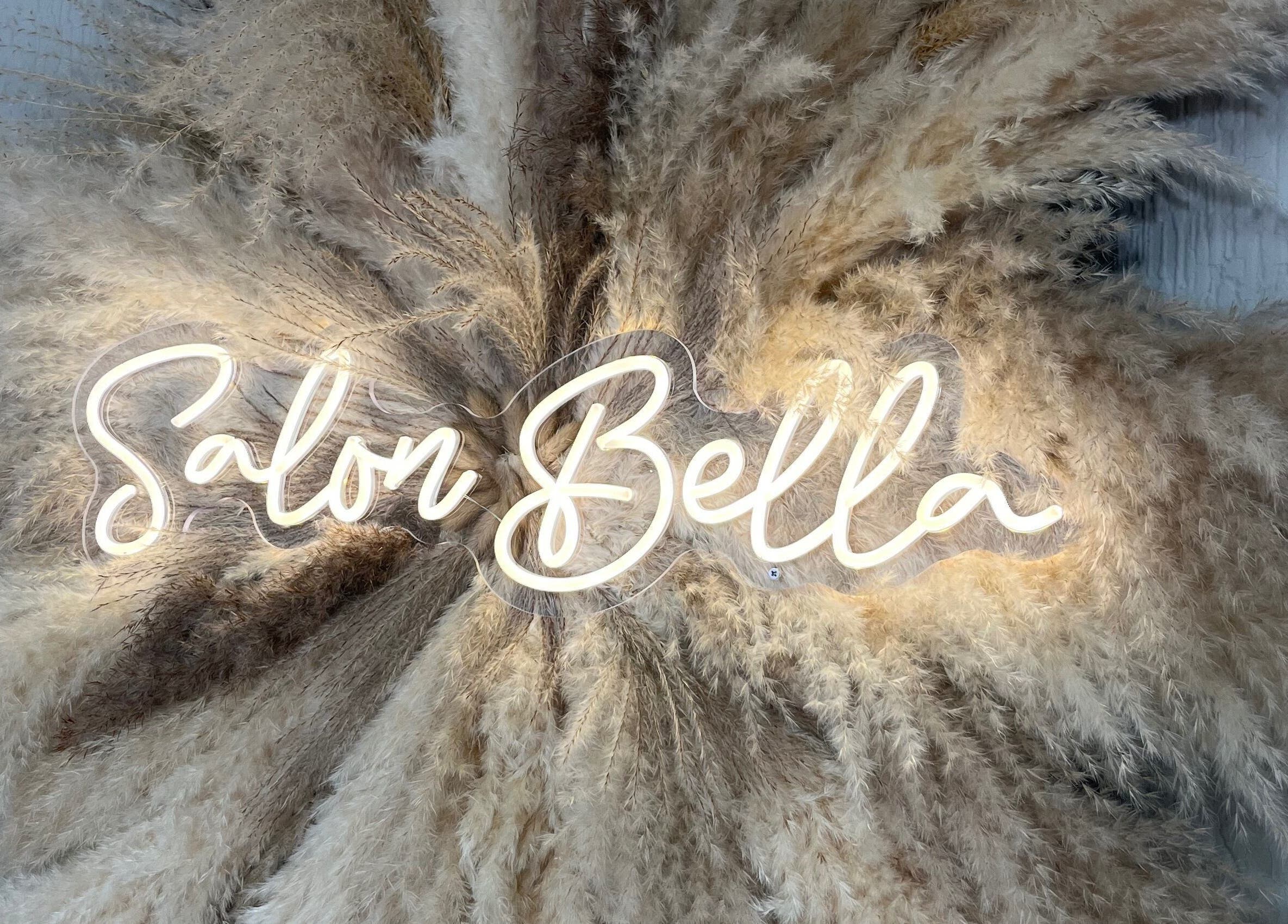 Elegant 'Salon Bella' neon sign surrounded by pampas grass at Bella by Ella, Douglas, Douglas, IM.