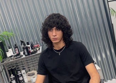 Cliente con estilo moderno en Bigote.Barber, Puente Genil, Andalucía, ES, junto a productos de cuidado capilar.