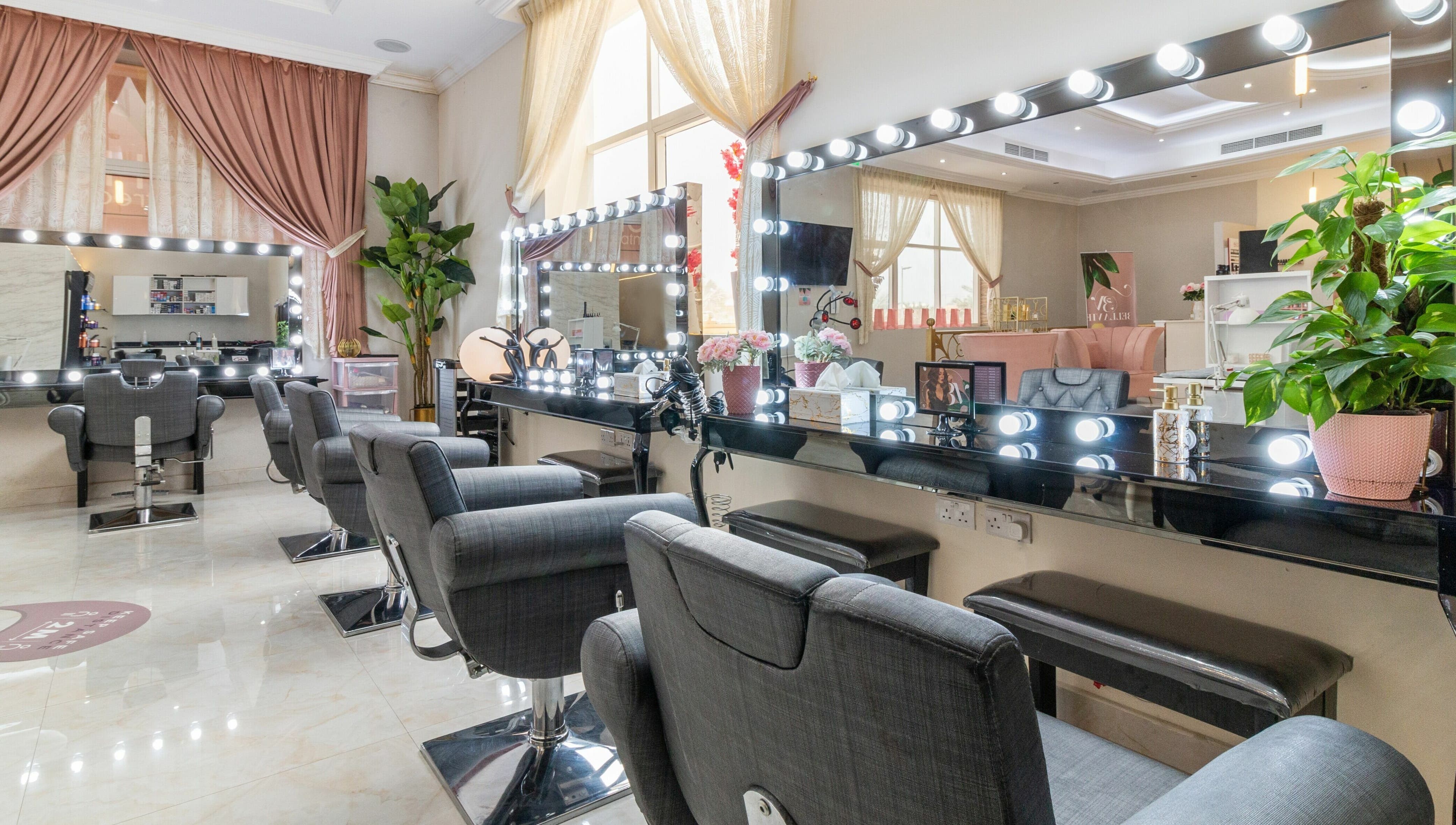 Elegant beauty stations at BellaVie Beauty Salon and Spa, Dubai, AE with plush chairs and illuminated mirrors.