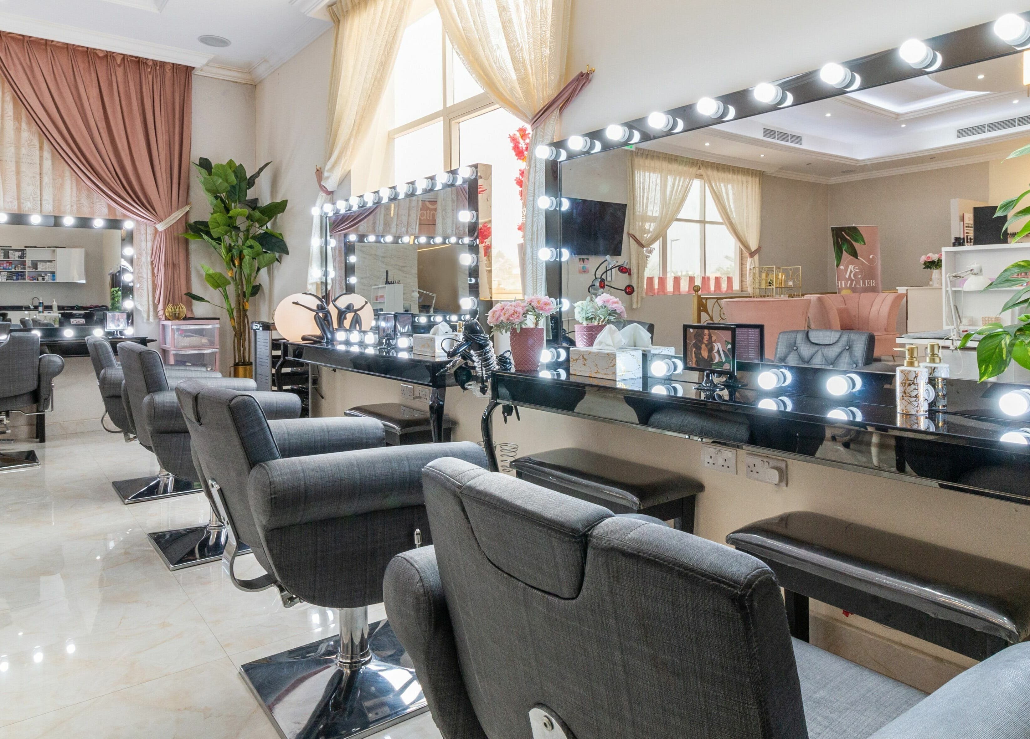 Elegant beauty stations at BellaVie Beauty Salon and Spa, Dubai, AE with plush chairs and illuminated mirrors.