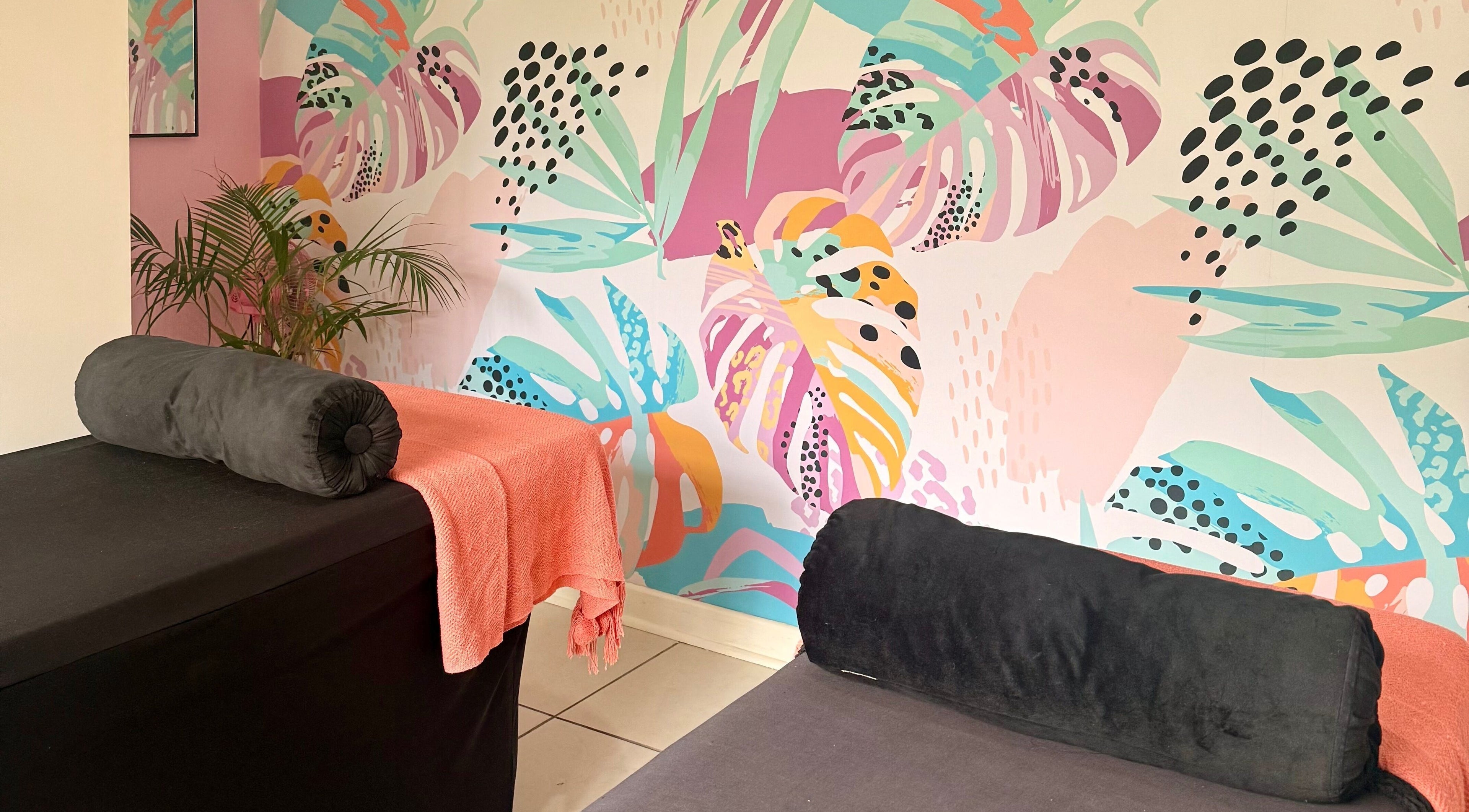 BM Pressed's vibrant floral wellness room in Westville, Kwazulu-natal, ZA, featuring colorful wall art and spa beds.