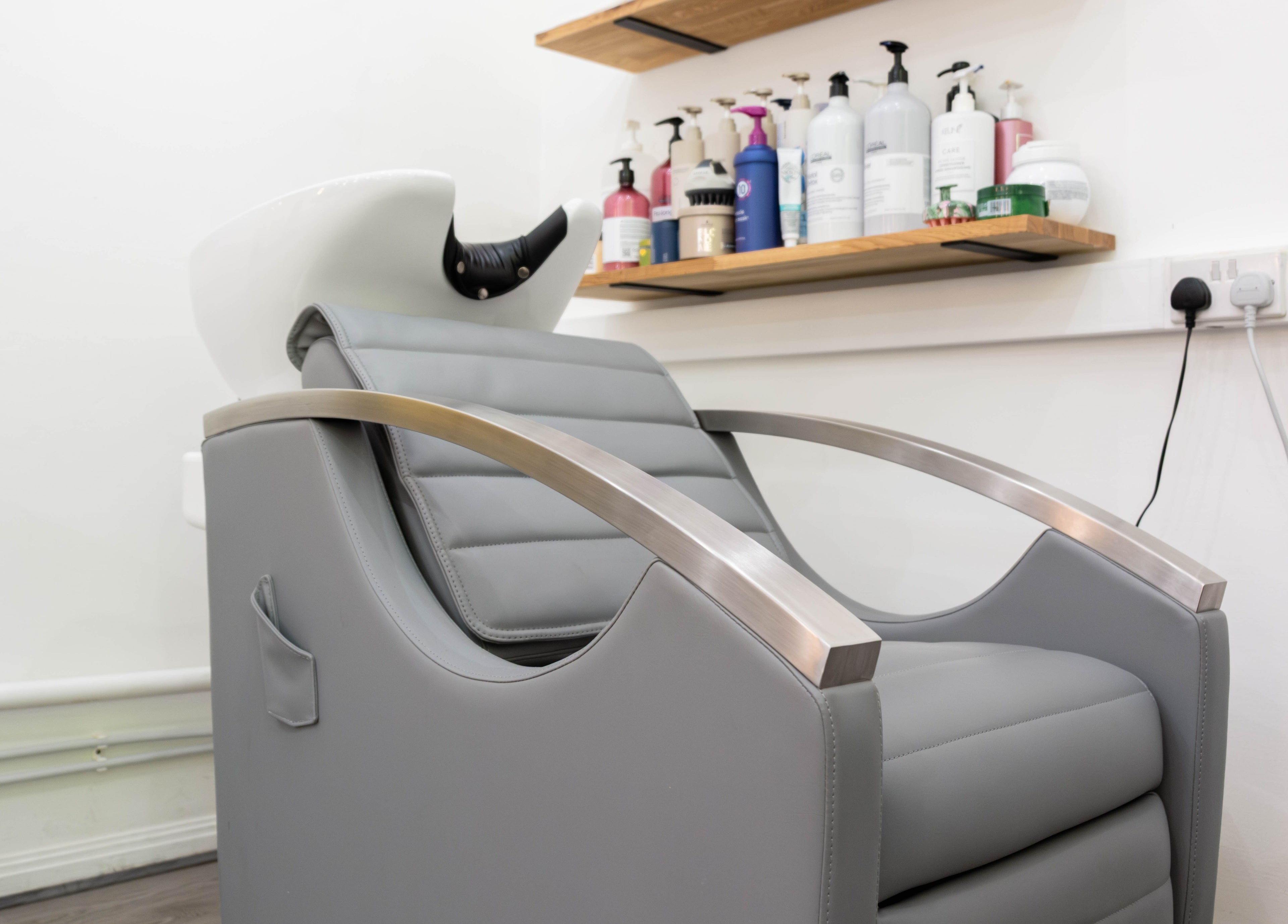 Sleek salon chair at Hair Rituals by Ariana, London, England, GB, offering a luxurious hair wash experience.