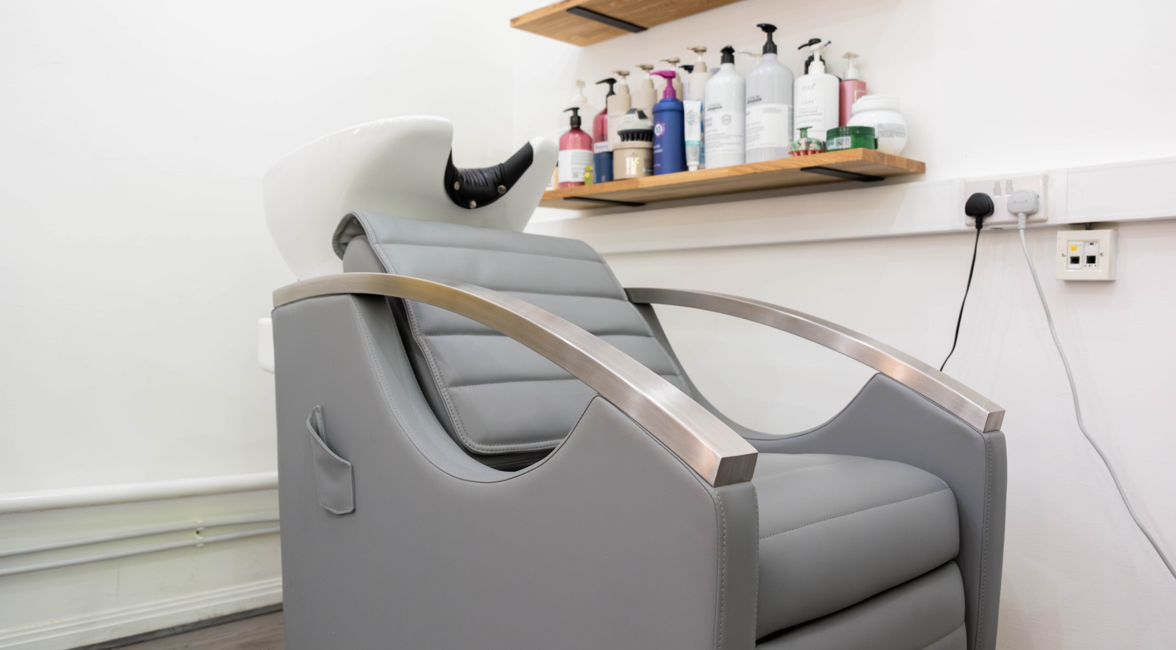 Sleek salon chair at Hair Rituals by Ariana, London, England, GB, offering a luxurious hair wash experience.