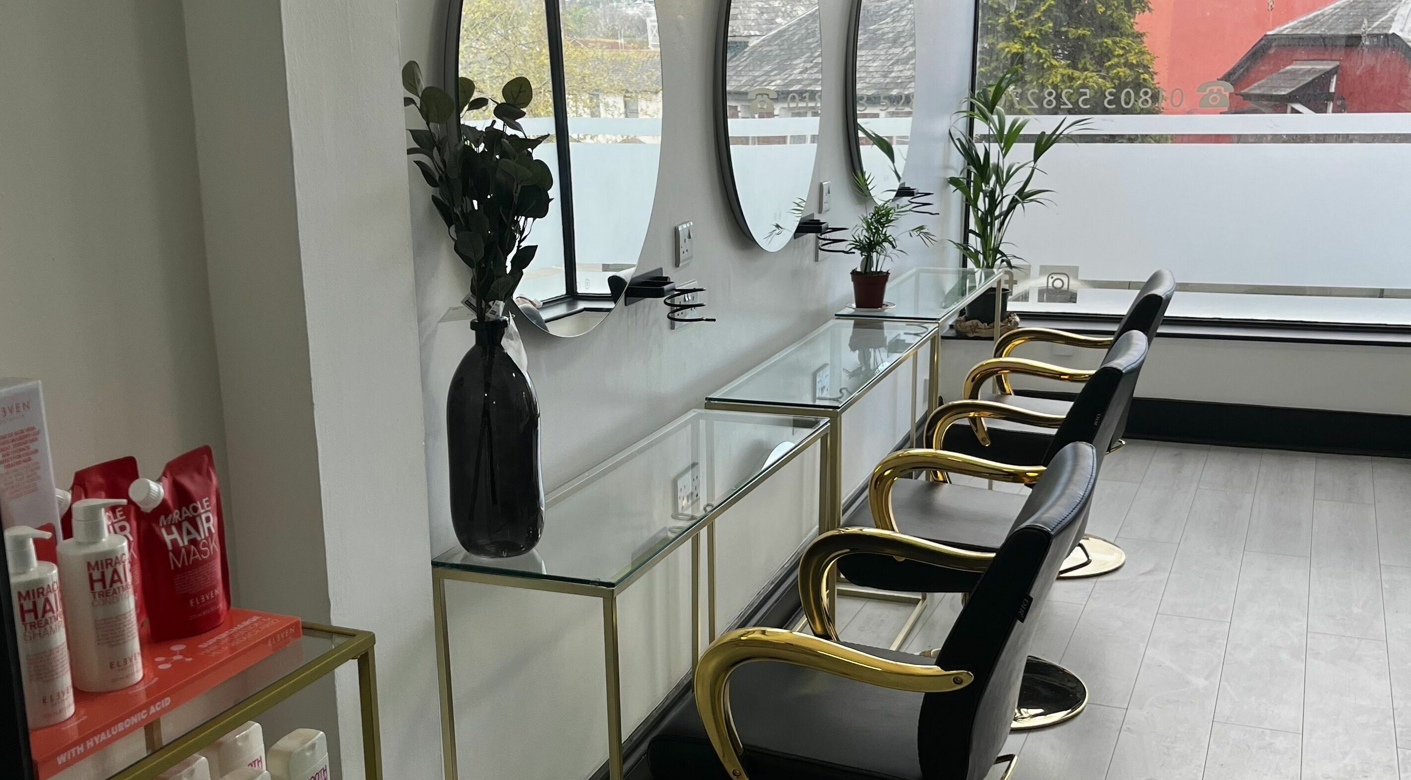 Stylish interior of Cult Hair Artistry in Paignton, England with elegant chairs and mirrors.