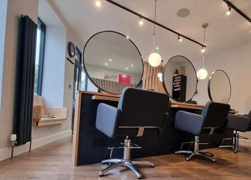 Modern salon interior at Onesixeight, Boston Spa, England, GB with stylish seating and mirrors.