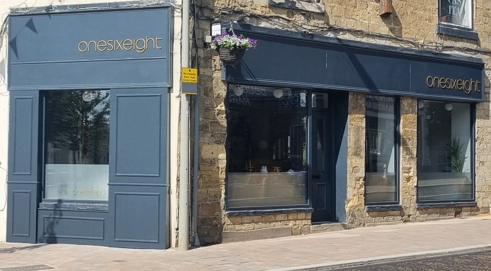 Exterior of Onesixeight beauty spa in Boston Spa, England with classic stone and navy blue design.