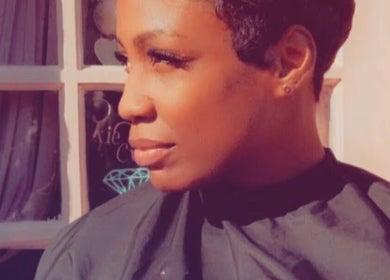 Customer at Virtuosa Hair Atelier Hairdressing, Hemel Hempstead, England, enjoys styled hair near window.