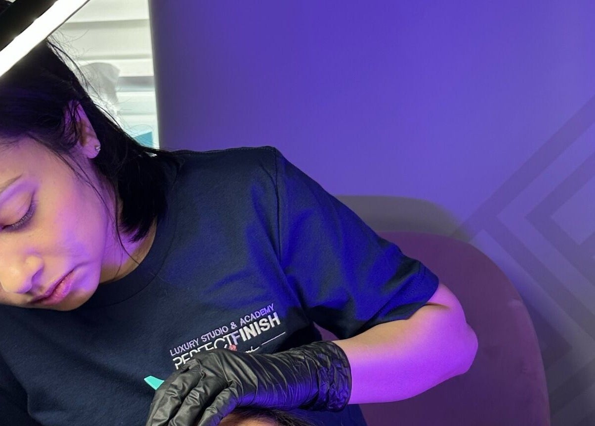 Artist applying lashes at Lash by Shumi - Luton Parkway, Luton, England, GB under soft lighting.