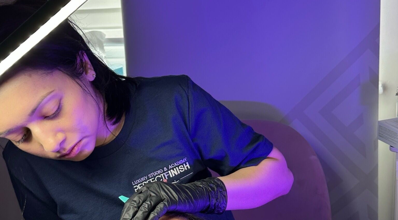 Artist applying lashes at Lash by Shumi - Luton Parkway, Luton, England, GB under soft lighting.