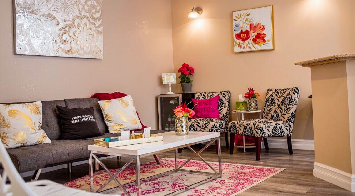 Cozy chic lounge at Allure Aesthetics, Great Falls, Montana, US, with floral decor and modern seating.