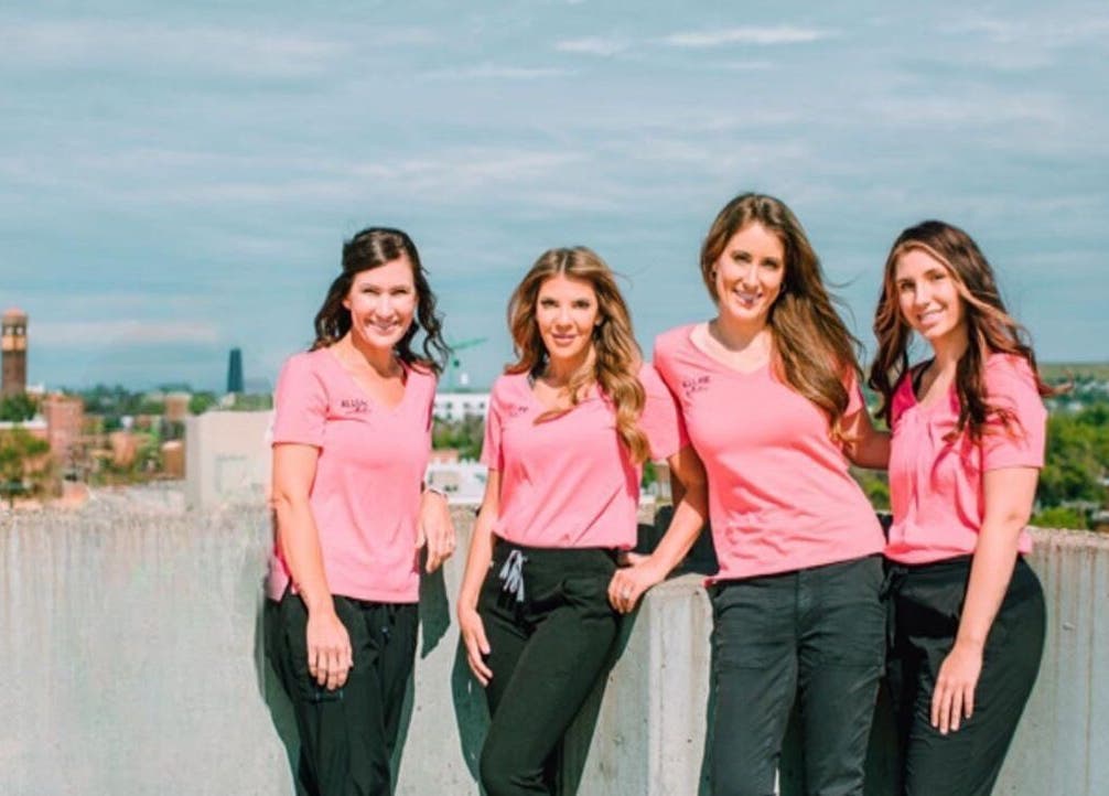 Allure Aesthetics team in pink uniforms on rooftop, Great Falls, Montana, US.