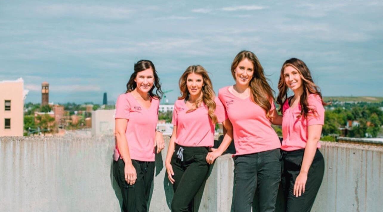 Allure Aesthetics team in pink uniforms on rooftop, Great Falls, Montana, US.