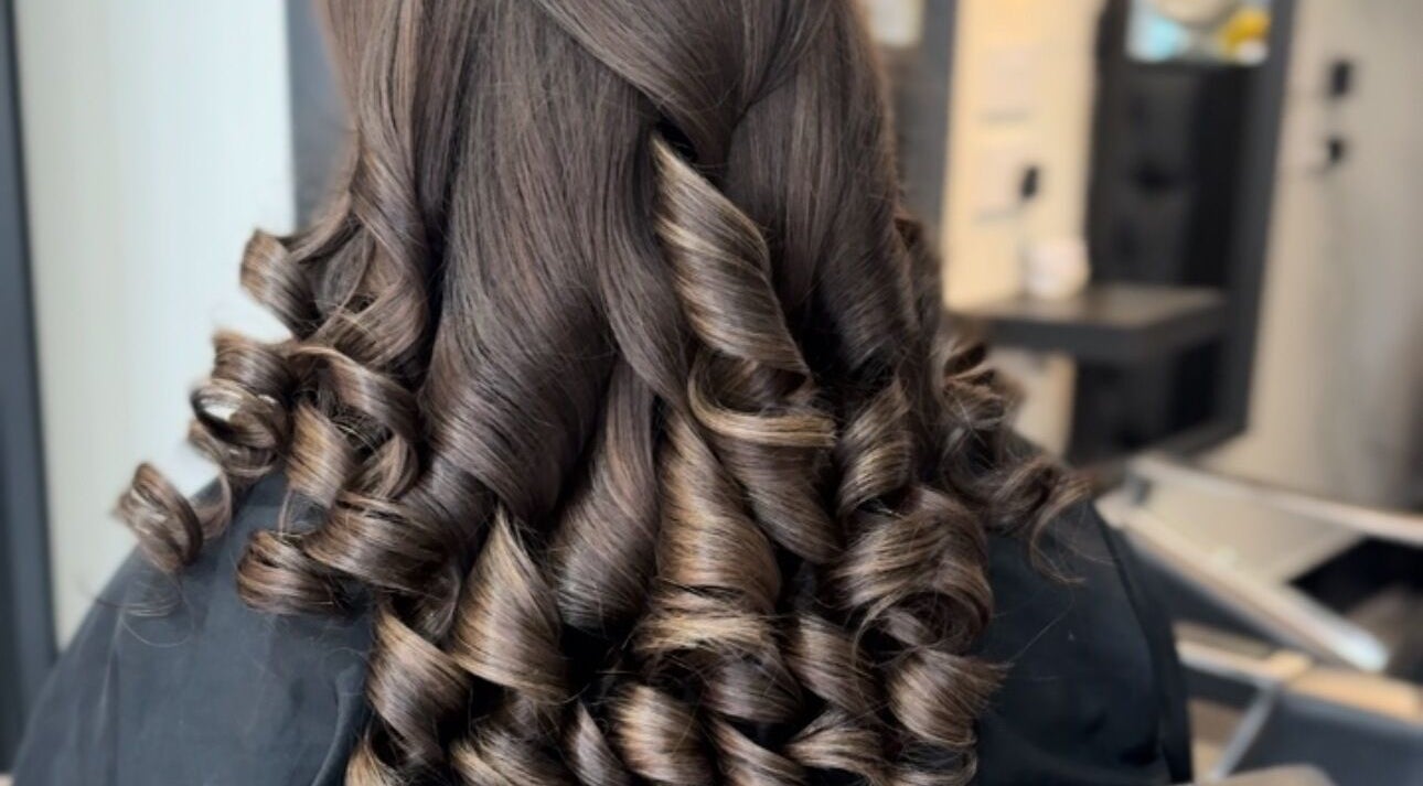 Elegant brown curls styled at Eleanor Rose Hair, Accrington, England, GB for a glamorous look.