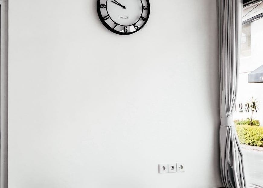 Modern interior at LASER ME ULUWATU, Bali, Bali, ID, featuring a wall clock and a view outside.