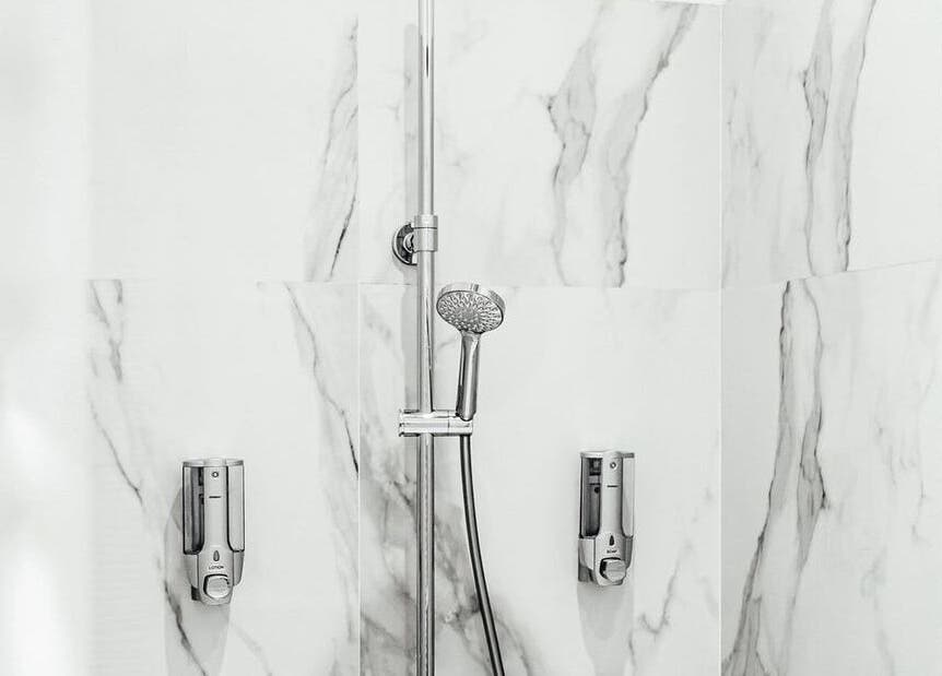 Elegant marble shower area at LASER ME ULUWATU, Bali, Bali, ID showcasing luxurious chrome fixtures.