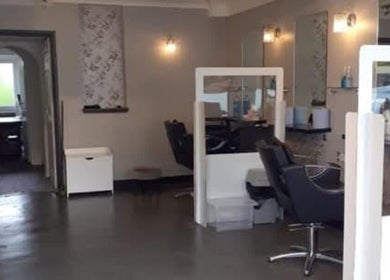 Modern interior of Ella @ TheSalon in Norwich, England, GB showcasing chic stylists' stations.