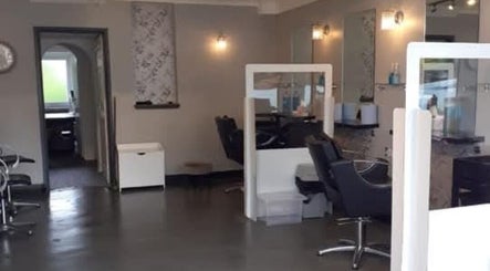 Modern interior of Ella @ TheSalon in Norwich, England, GB showcasing chic stylists' stations.