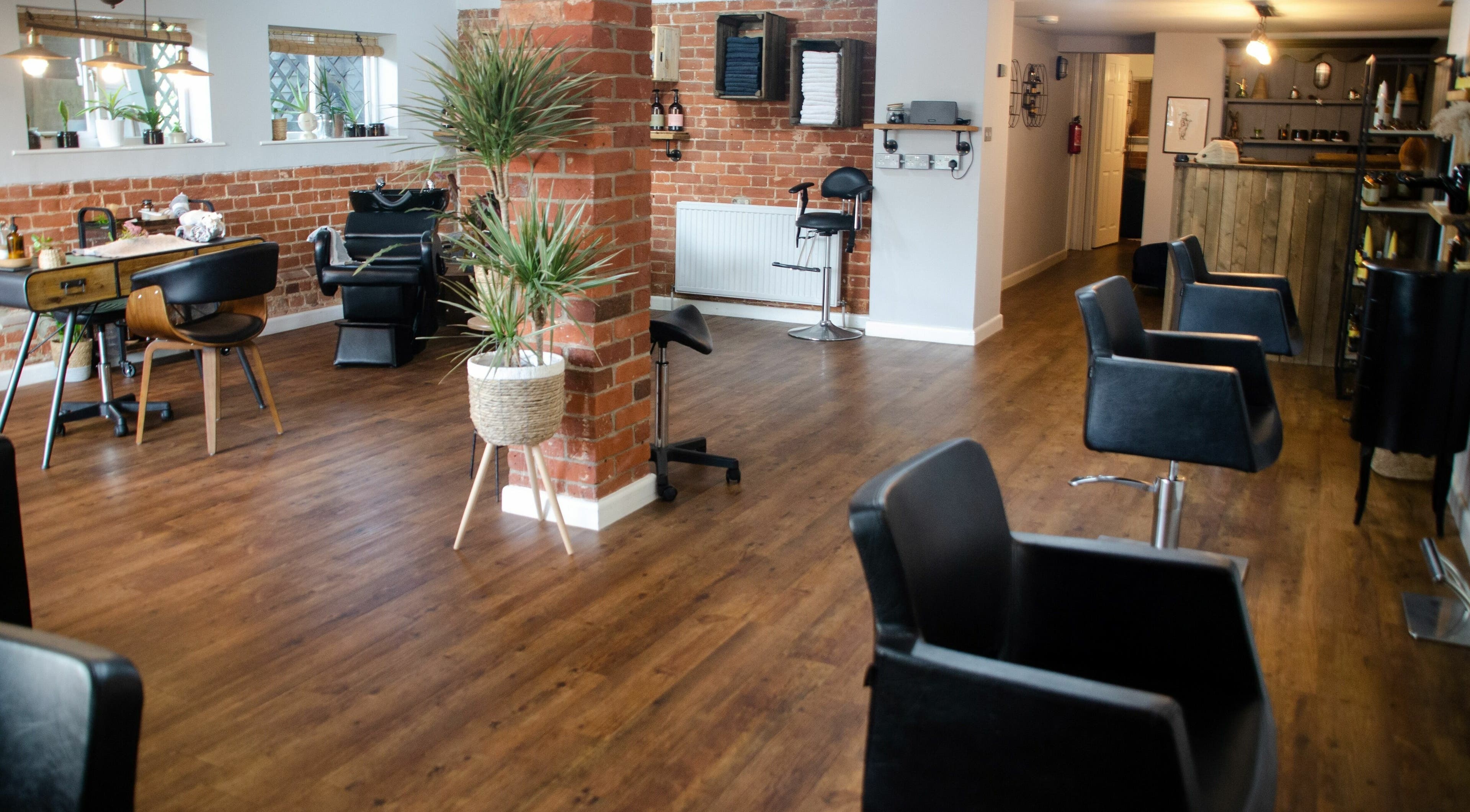 Modern interior of Vinesse Ethical Hair & Beauty, Lavenham, England, GB, featuring stylish salon chairs and decor.