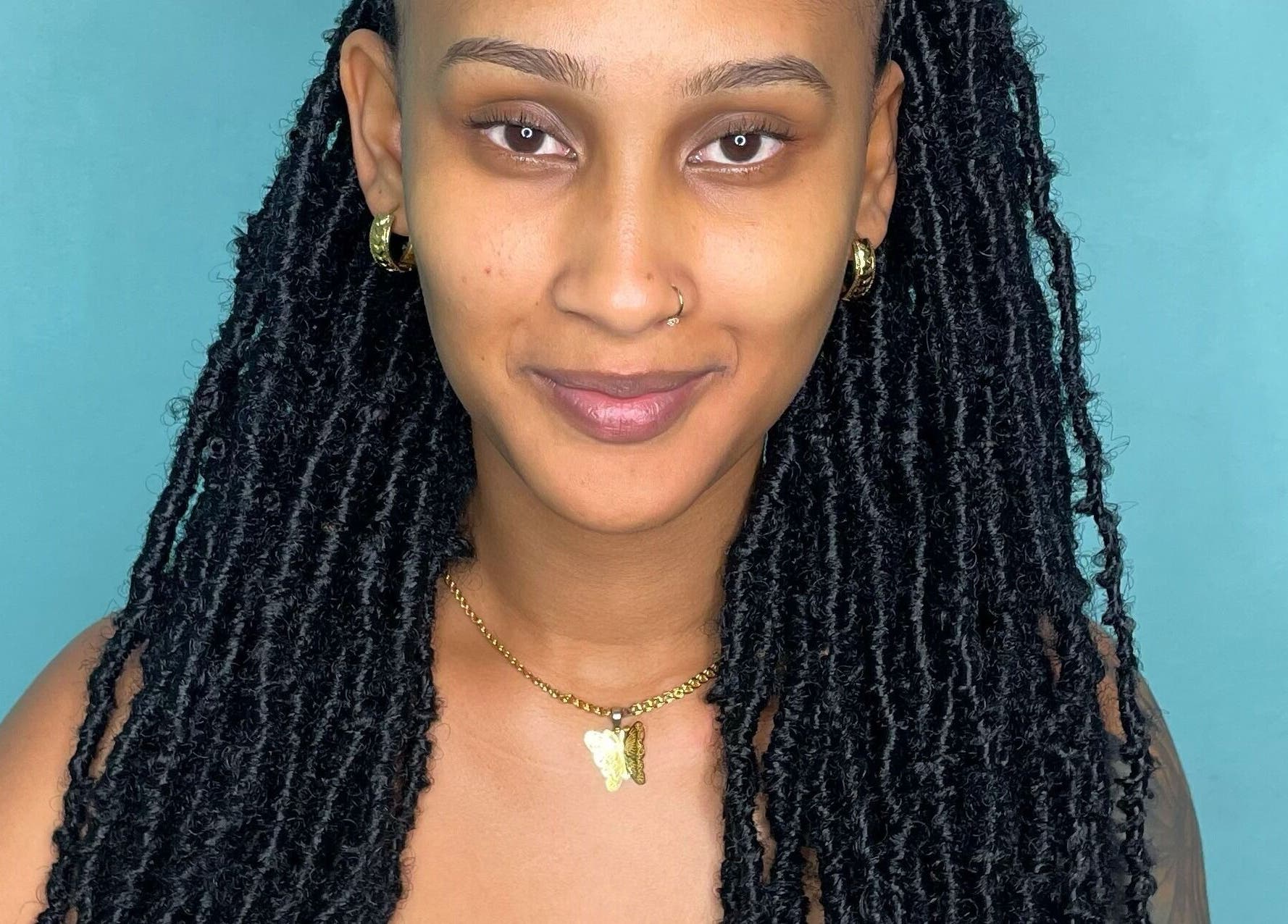 A smiling individual with styled hair at Savoir Beauty Ltd, Point Fortin, TT.