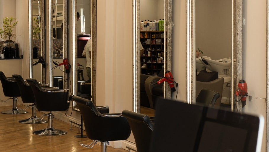 Stylish interior of TOQQA Hair Salon in London, England, GB with elegant chairs and mirrors.