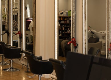 Stylish interior of TOQQA Hair Salon in London, England, GB with elegant chairs and mirrors.