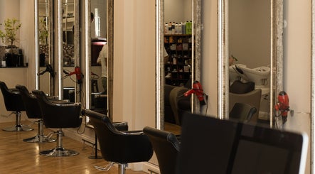Stylish interior of TOQQA Hair Salon in London, England, GB with elegant chairs and mirrors.