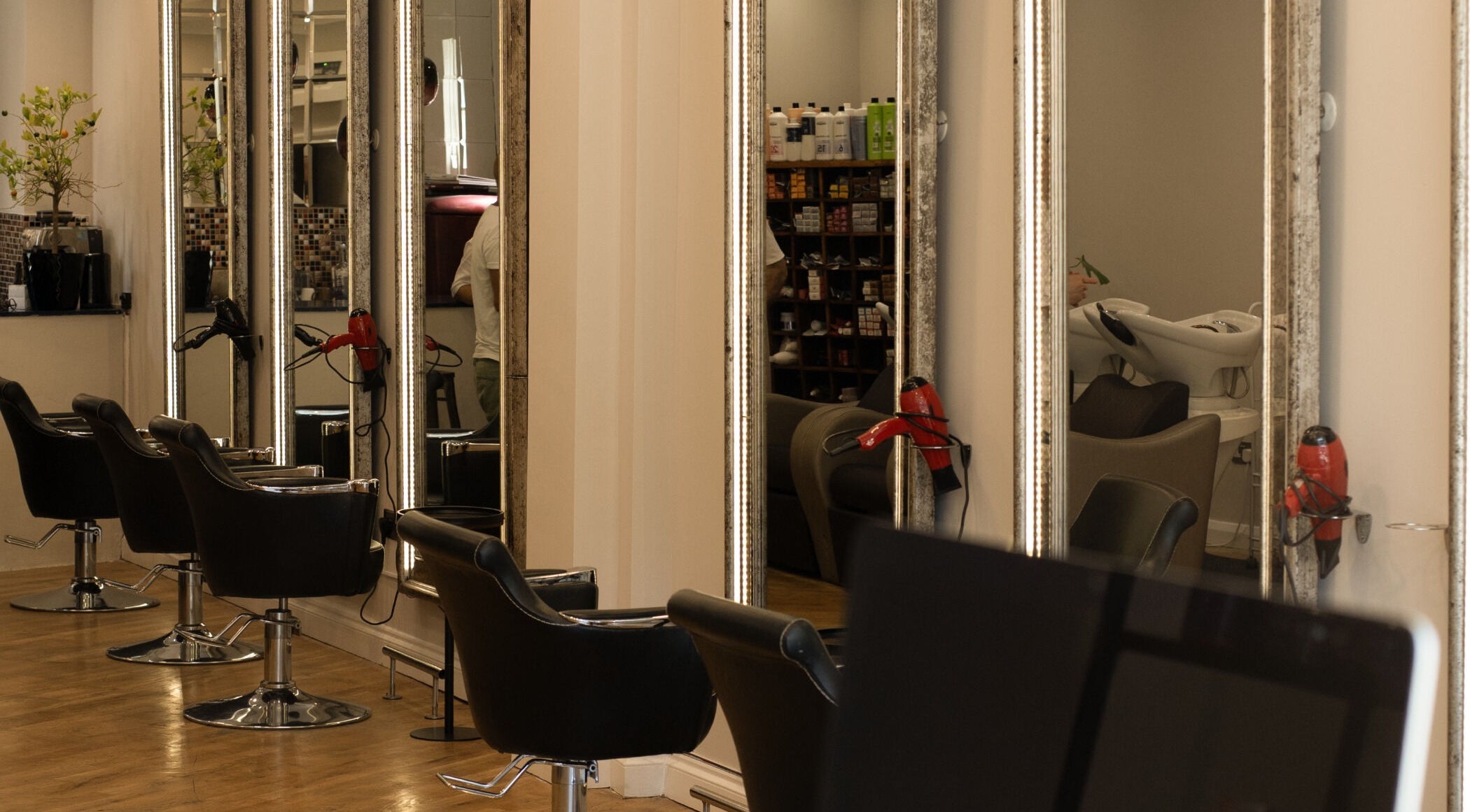 Interior of TOQQA Hair Salon in London, England, GB featuring stylish mirrors and salon chairs.