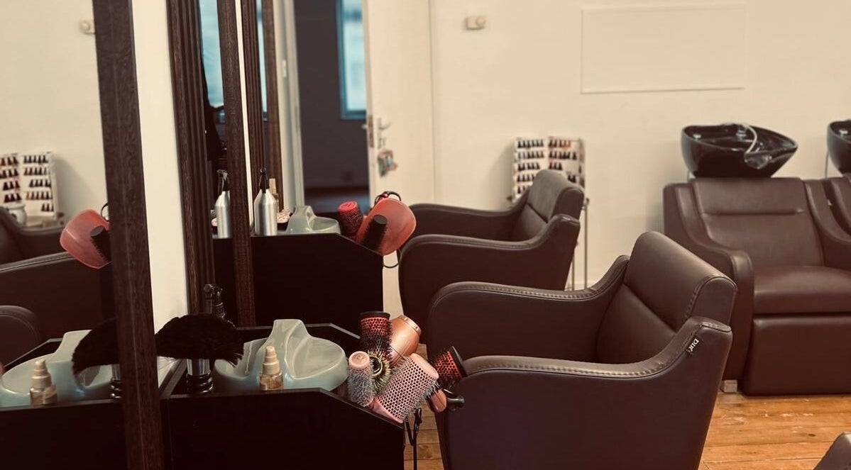 Chic interior of Models Hair & Beauty salon in Colchester, England, GB, featuring sleek styling chairs and mirrors.
