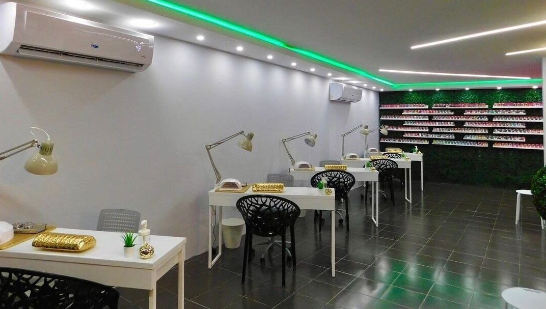 Interior moderno de Cortauñas Salón en Carolina, US mostrando mesas de manicura y decoración elegante.