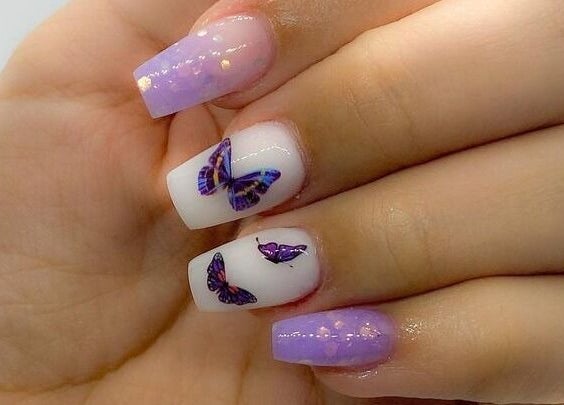Uñas decoradas con mariposas violetas en Cortauñas Salón, Carolina, US.