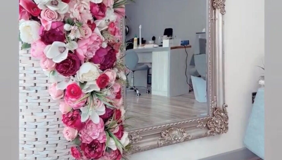 Ndila Beauty Academy's elegant salon in Manchester, England, GB features a stylish mirror and vibrant flower decor.