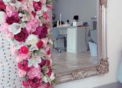 Ndila Beauty Academy's elegant salon in Manchester, England, GB features a stylish mirror and vibrant flower decor.