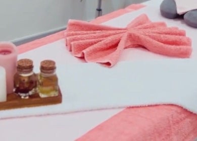 Ndila Beauty Academy massage table with pink towels and oils in Manchester, England, GB.