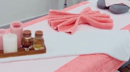 Ndila Beauty Academy massage table with pink towels and oils in Manchester, England, GB.