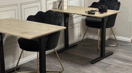 Modern workspace at Ndila Beauty Academy, Manchester, England, GB with chic chairs and wooden desks.