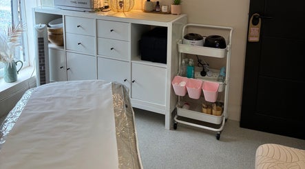 A tranquil treatment room at The Solar Skin Club Ramsgate in Ramsgate, England, GB, with organized shelving.