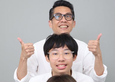 Smiling people at Photonow @ Centrepoint, Singapore, Singapore, SG holding thumbs up against a gray background.