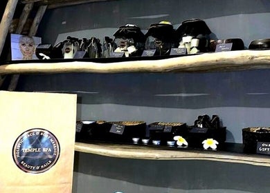 Luxurious spa products displayed on rustic shelves at Temple Spa Bali, Bali, ID, enhancing relaxation ambiance.