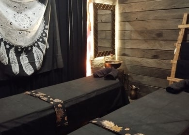 Peaceful spa room at Inka Spa Bali, Bali, ID with twin massage tables and rustic decor.