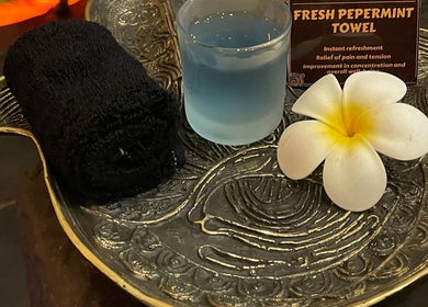Relaxing setup with a black towel, blue drink, and flower at Inka Spa Bali, Bali, Bali, ID.
