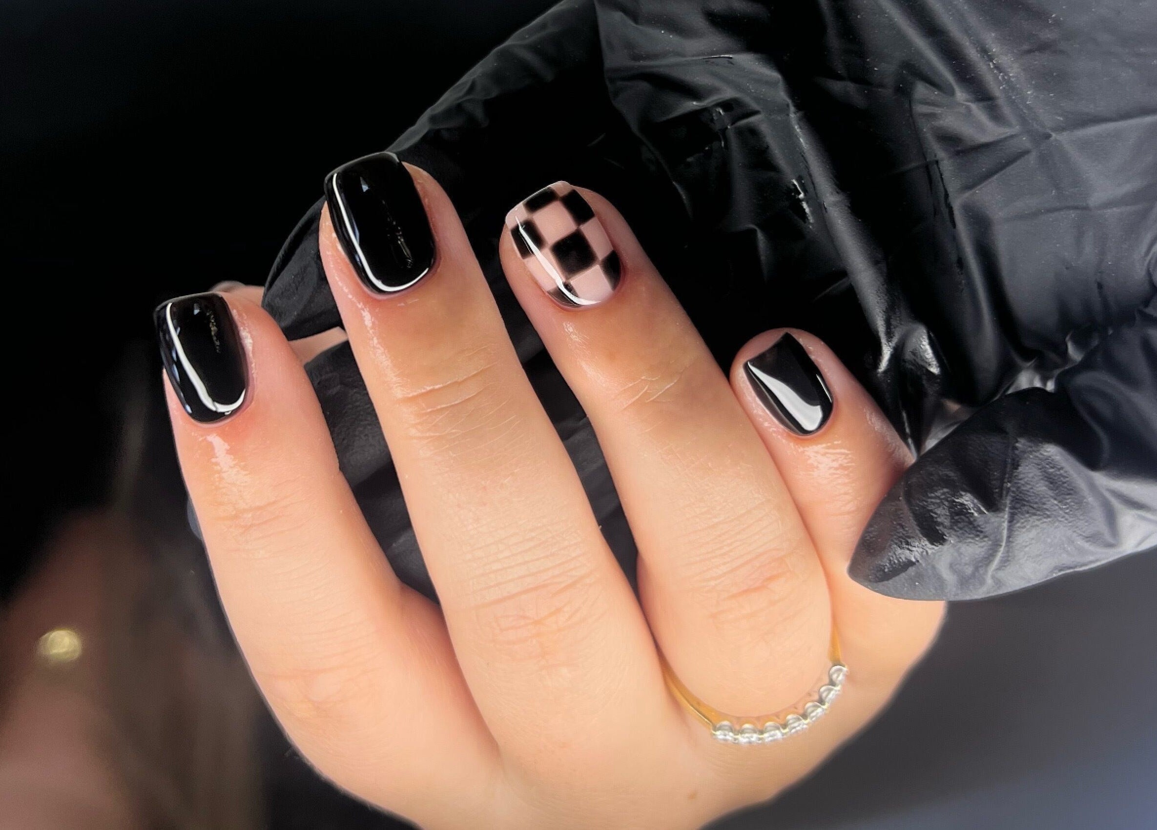 Stylish black and checkered nails at Byleahhm, Osgodby, England, GB. Sophisticated nail art in a cozy setting.