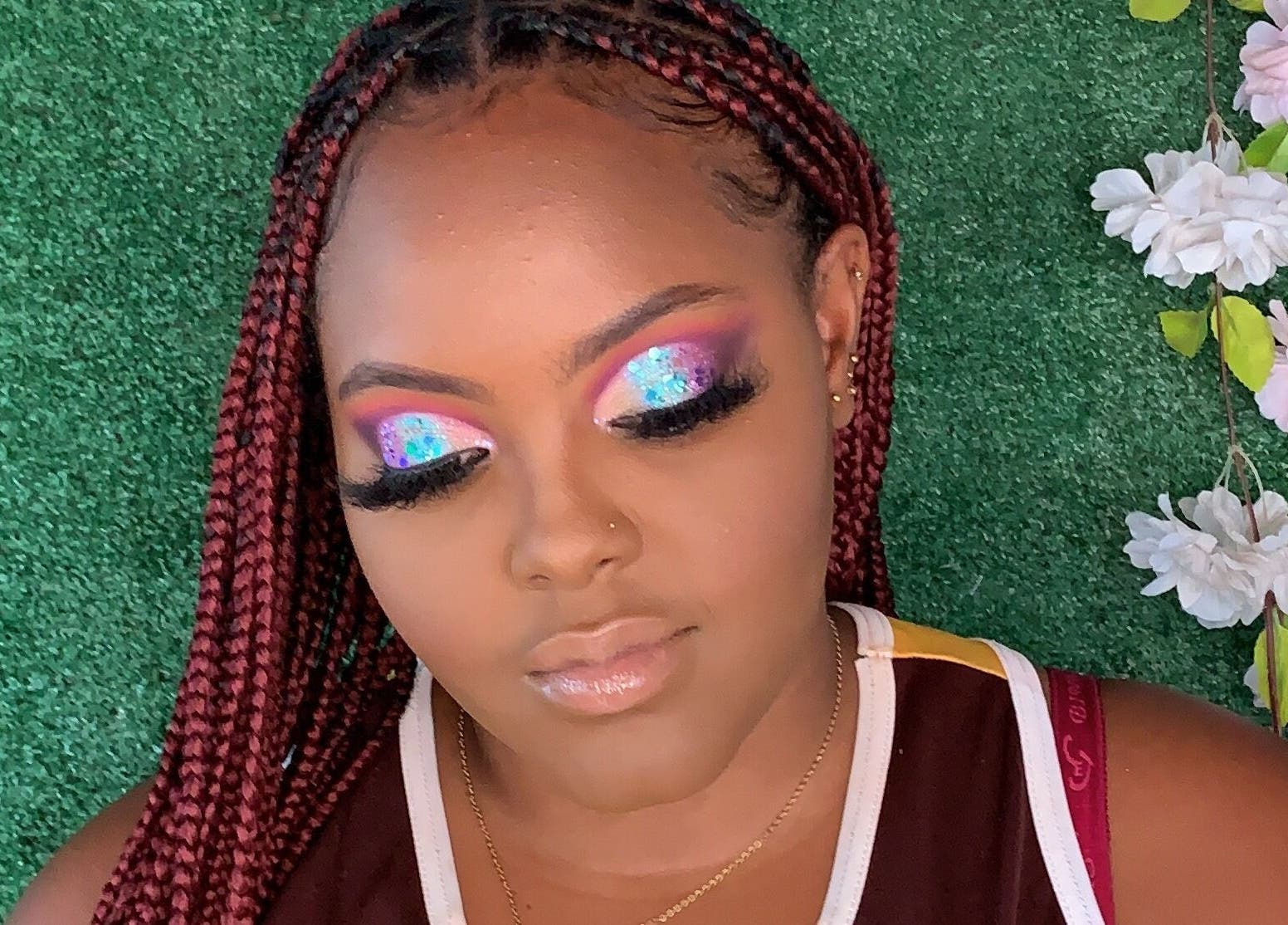 Vibrant eye makeup by Facebydrea at Kingston, St. Andrew Parish, JM with floral accents and lush greenery.