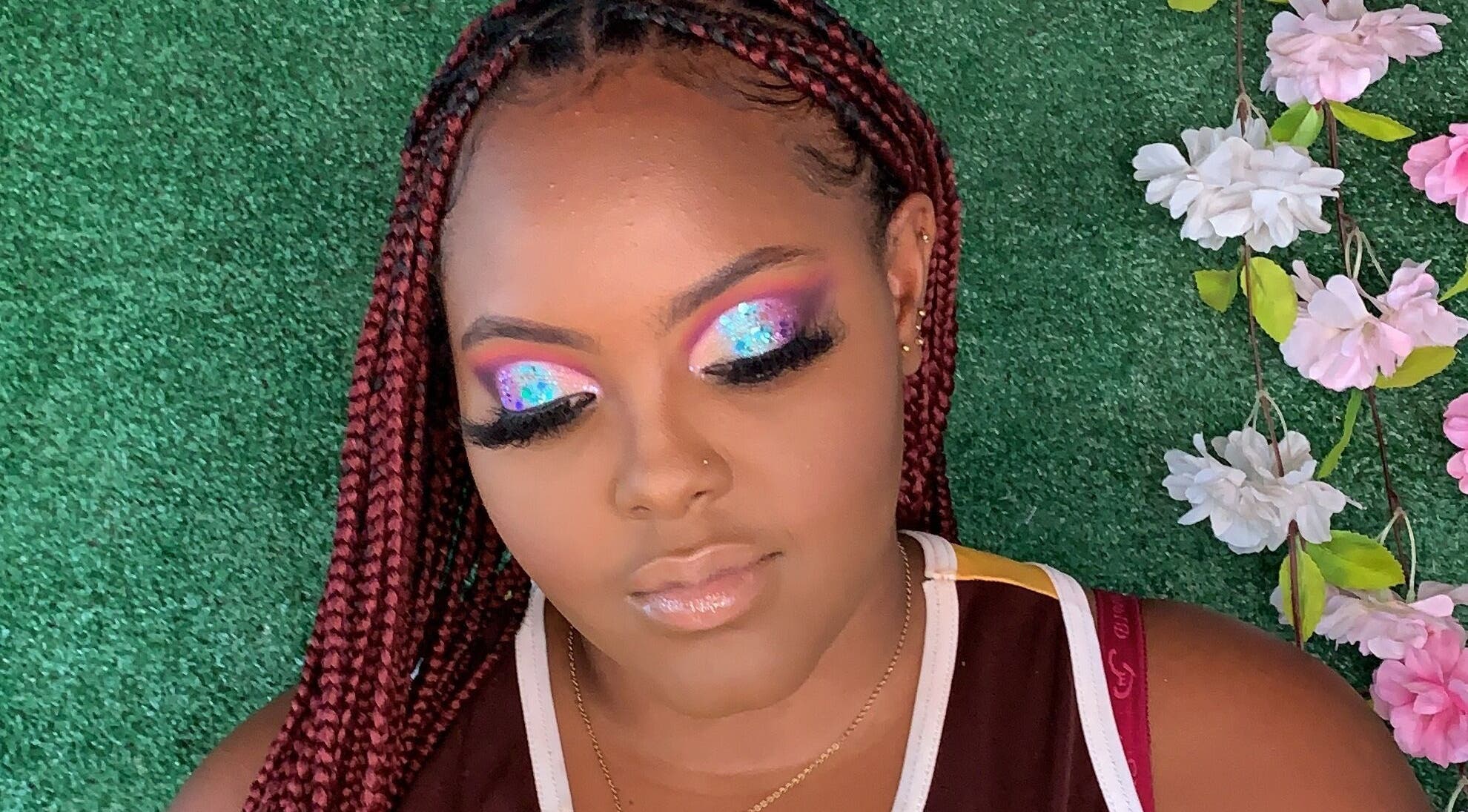 Vibrant eye makeup by Facebydrea at Kingston, St. Andrew Parish, JM with floral accents and lush greenery.