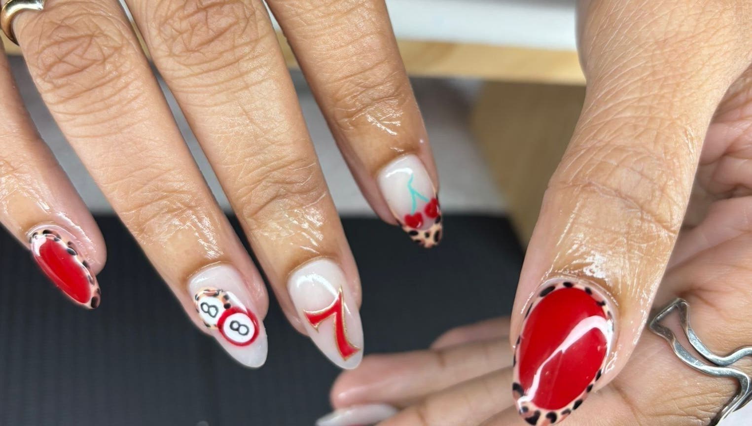Creative nail art at The Lab ltd in London, England, GB, featuring vibrant designs with red and leopard accents.