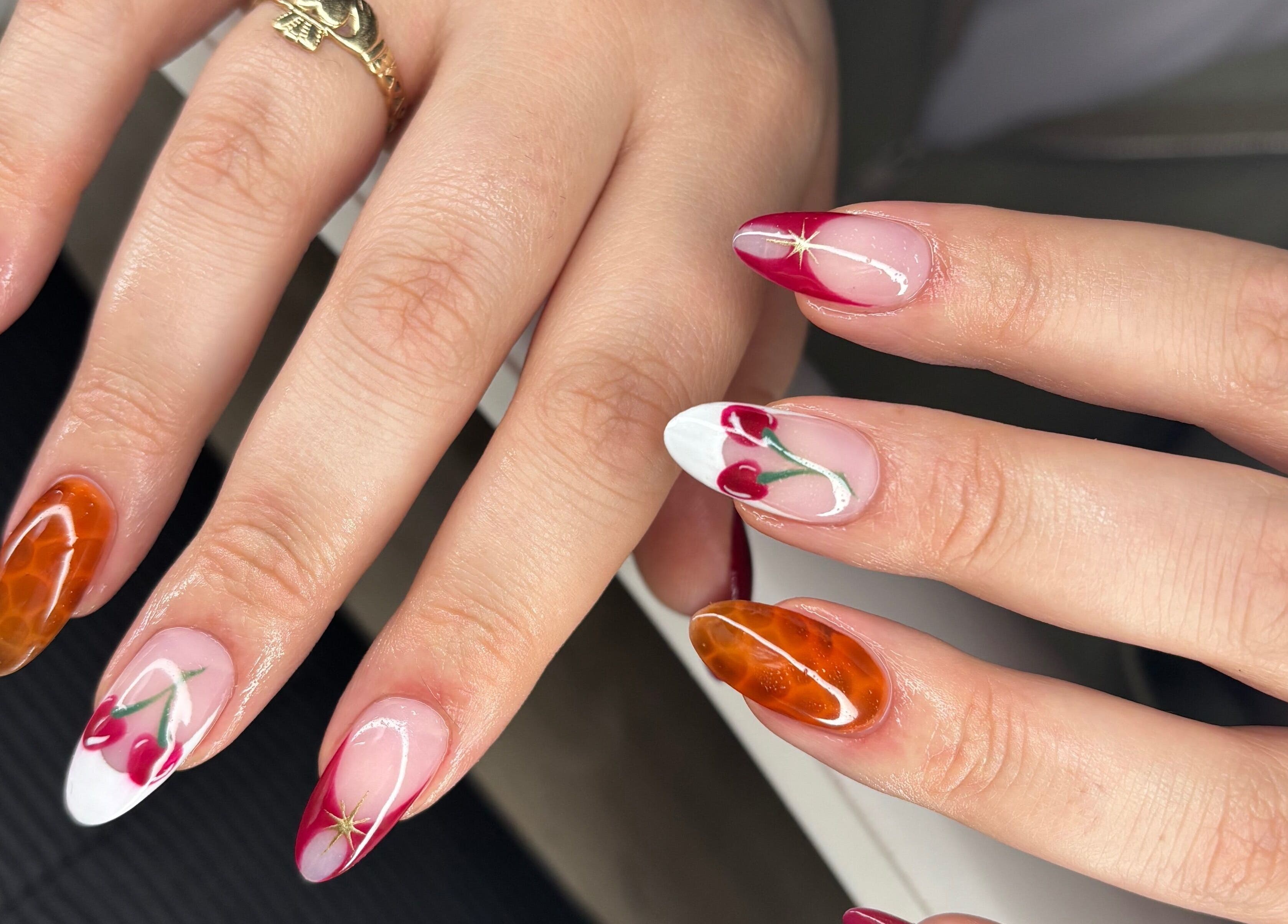 Elegant nail art design at The Lab ltd, London, England, GB with cherry and amber motifs.
